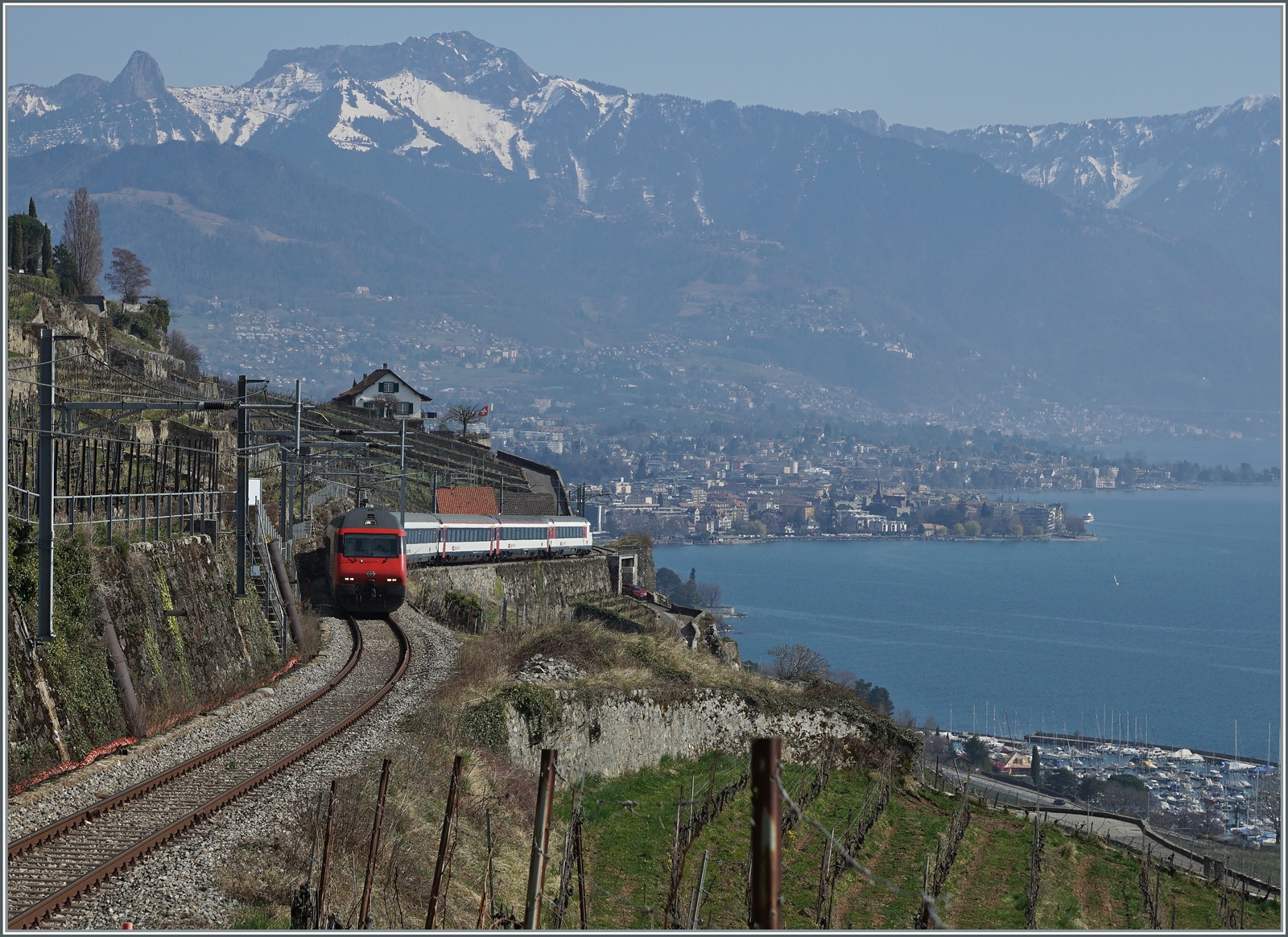 Umleitungsverkehr via die  Train de Vignes -Strecke und Palézieux statt dem See entlang. Die ist für die Reisenden mit einem Zeitverlust verbunden, beschert aber herrliche Ausblicke Eine SBB Re 460 ist oberhalb von St-Saphorin mit einem IR 90 auf dem Weg in Richtung Lausanne.

20. März 2022