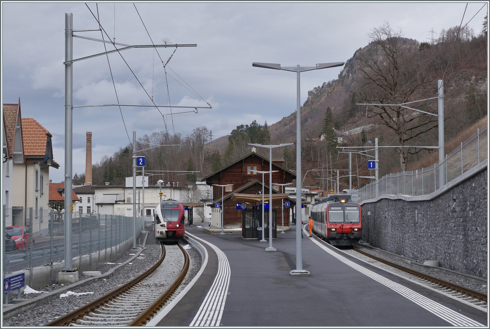Viel Verkehr in Broc Chocolaterie. jedenfalls sind nun beide verfügbaren Gleise besetzt: auf Gleis 2 ist der TPF RABe 527 194 als RE 3816 von Bern angekommen, während auf Gleis 1 der TPF RBDe 560 240 (mit dem Steuerwagen ABt 39-43 863-2 an der Spitze) als RE 3819 auf die baldige Abfahrt nach Bern wartet. In der Regel wenden die Züge direkt in sechs Minuten, einige Male pro Tage wird wohl aus Umlaufgründen die Kompositionen wie hier ausgetauscht, so wird der TPF RABe 527 194 erst um 14:03 nach Düdingen zurückfahren.

24. Januar 2024