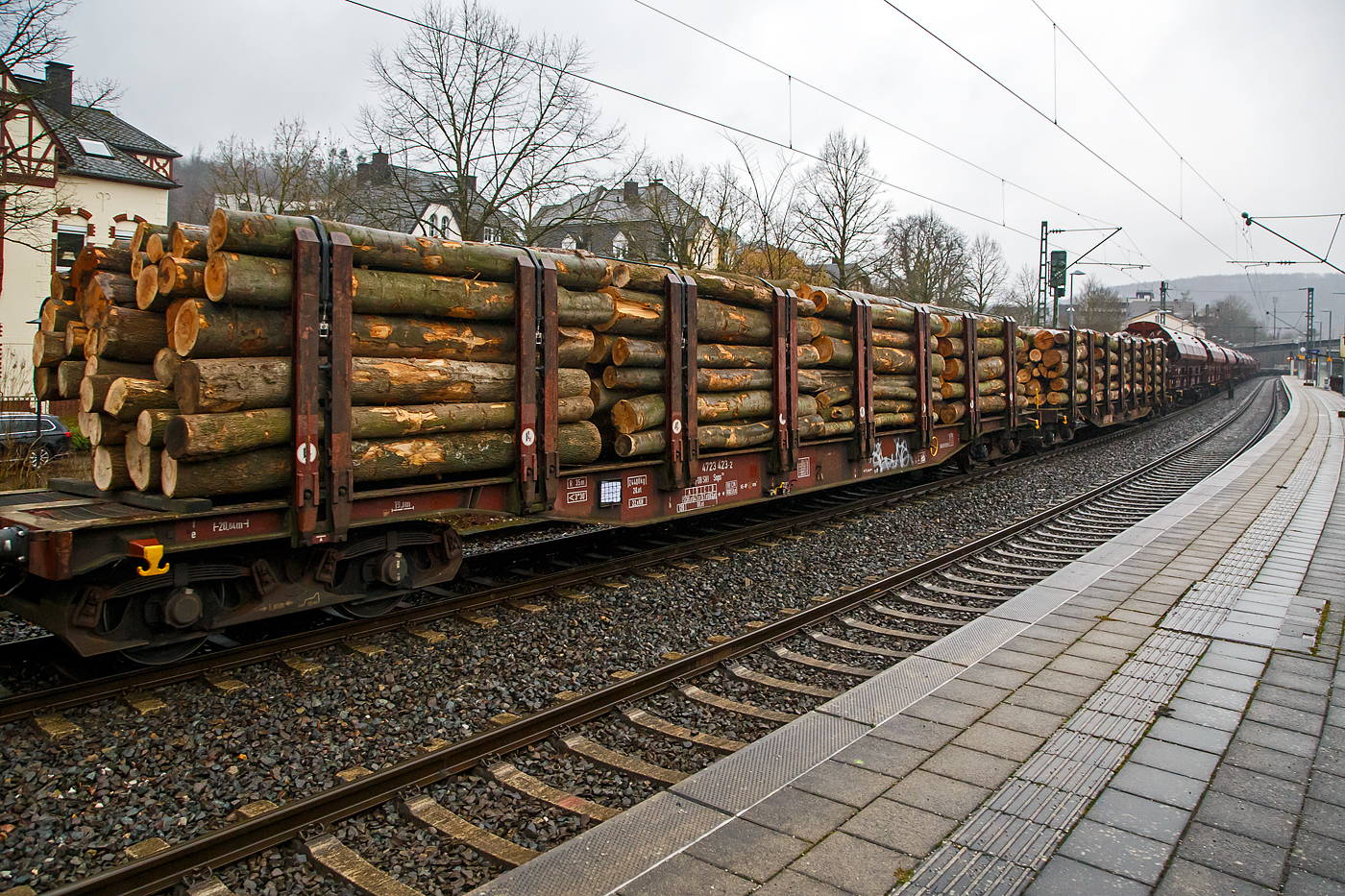 Vierachsiger Drehgestell-Flachwagen Doppelrungen und Niederbindeeinrichtung, 31 80 4723 423-2 D-DBSNI, der Gattung Snps 719 der DB Cargo Logistics GmbH (ex DB Schenker Nieten GmbH), beladen mit Buchen-Rundholz am 31.01.2023 im Zugverband bei der Durchfahrt in Kirchen (Sieg).

Diese Drehgestell-Flachwagen wurde speziell für den Transport von Rohren, Profilstahl, Flachstahlprodukten, sowie Stamm- und Schnittholz entwickelt und zeichnet sich durch hohe Ladekapazität und optimierte Ladesicherung aus. Sie wurden ab 1980 als Sps 719 beschafft und ab 1988 in Snps 719 umgezeichnet.

Zur Aufnahme und Abstützung der Ladung sind auf dem Wagenboden Ladeschwellen und an den Wagenlängsseiten Rungen angebracht. Zur Verzurrung der Ladung sind von Hand zu bedienende Niederbindeeinrichtungen vorhanden. Für die Auflage des Ladegutes sind hölzerne Ladeschwellen im Rungenbereich und im Abstand von 1 m von Wagenende vorhanden. Außerdem sind feste 5 mm niedrigere Hilfsladeschwellen zwischen den Rungen zur Unterstützung von leicht durchhängendem Ladegut (z. B. Schnittholz) angeordnet. Die Ladeschwellen sind genügend hoch, so dass die handelsüblichen Umschlagmittel verwendet werden können. Der Wagenboden ist mit einem begehbaren Loch- bzw. Riffelblech vollständig abgedeckt. Zur Aufnahme von Lasten oder zum Befahren mit Flurförderfahrzeugen sind die Abdeckungen nicht geeignet. Zur Sicherung der Ladung sind auf jeder Wagenlängsseite in gleichmäßigen Abständen 8 Rungen vorhanden. Die Rungen sind mit dem Untergestell-Außenlangträger fest verbunden und so ausgeführt, dass sie die durch die Ladung entstehenden Kräfte in Wagenlängs- und Wagenquerrichtung sicher aufnehmen können. Die Innenseiten der Rungen sind ausgekleidet.

Zur Verzurrung des Ladegutes ist jedes Rungenpaar mit einer Niederbindeeinrichtung ausgerüstet, die von einer Person bedient werden kann. Die Spanngurte sind zur Schonung des Ladegutes mit einem elastischen Werkstoff ummantelt. Die Länge des Gurtes und die Teilung der Raster sind so gewählt, dass auch Ladungen, die nur etwa die halbe Rungenhöhe einnehmen, verzurrt werden können.

TECHNISCHE DATEN:
Gattung: Snps 719
Spurweite: 1.435 mm (Normalspur)
Länge über Puffer: 20.840 mm
Drehzapfenabstand: 15.800 mm
Radsatzstand in den Drehgestellen: 1.800 mm
Ladelänge: 19.000 mm
Ladebreite: 2.723 mm (zwischen den Rungen)
Fußbodenhöhe über SO: 1.280 mm (OK Ladeschwelle)
Rungenhöhe: 2.000 mm
Eigengewicht: 24.400 kg
Zuladung bei Lastgrenze S: 63 t (ab Streckenklasse D)
Max. Geschwindigkeit: 100 km/h / 120 km/h (leer)
Kleinster Gleisbogenhalbmesser: 35 m
Bauart der Bremse: KE-GP (LL)
Bremssohle: IP 116
Verwendungsfähigkeit: RIV