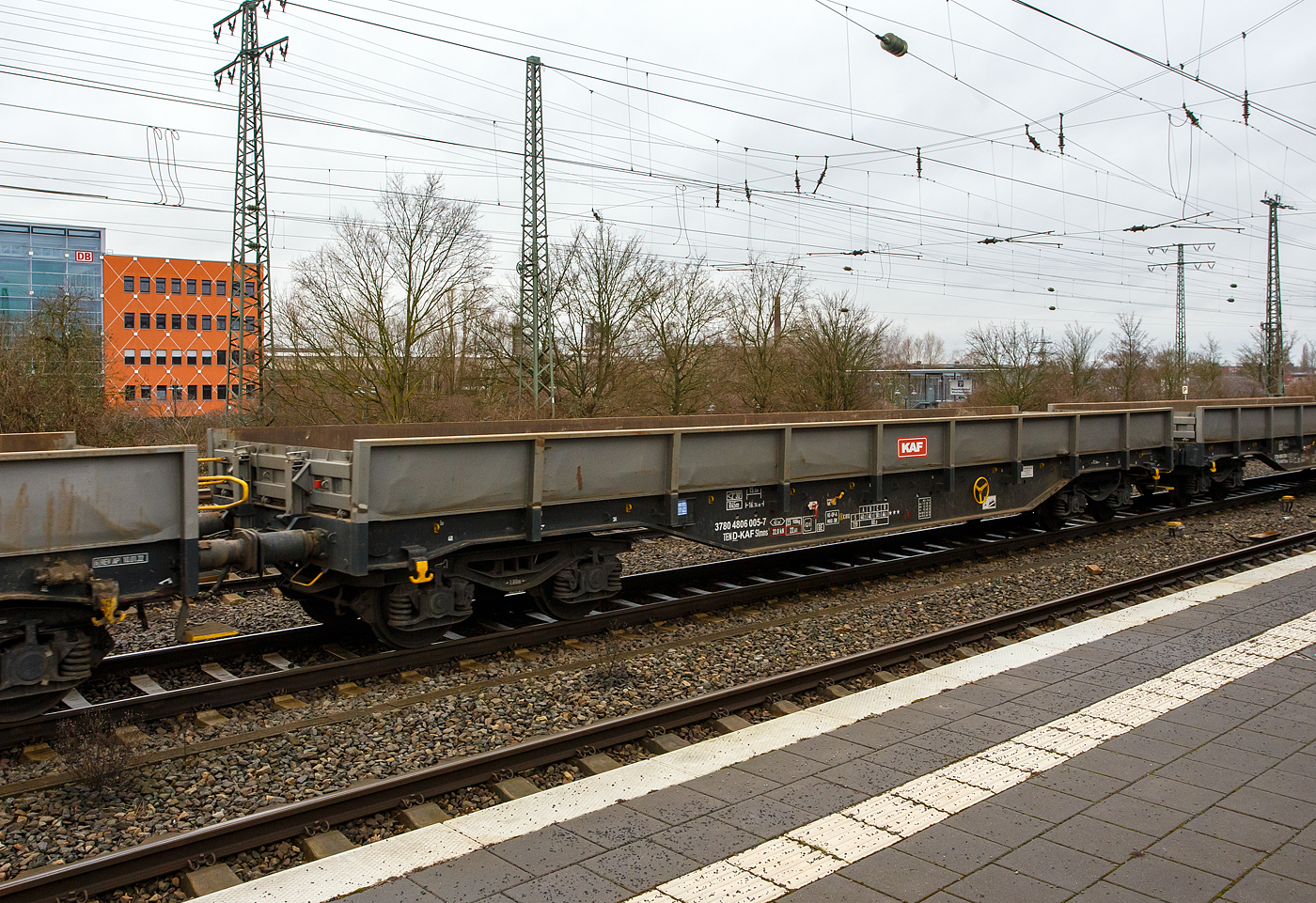 Vierachsiger Drehgestell-Flachwagen, mit festen Seitenwänden und Stirnwandklappen, 37 80 4806 005-7 D-KAF, der Gattung Slmns1, der KAF - Falkenhahn Bau AG (Kreuztal) , am 14 Februar 2024 im Zugverband (mit der FAF 271 006-9 „Julius“) bei einer Zugdurchfahrt beim Hauptbahnhof Hamm (Westfalen).

TECHNISCHE DATEN:
Spurweite: 1.435 mm (Normalspur)
Gattung/Bauart: Slmns1
Anzahl der Achsen: 4 in 2 Drehgestellen
Länge über Puffer: 16.740 mm
Drehzapfenabstand:  11.700 mm
Achsabstand in den Drehgestellen: 1.800 mm
Eigengewicht: 23.900 kg
Ladelänge: 15.500 mm
Ladefläche: 43,3 m²
Maximale Ladegewicht: 66,1 t (Streckenklasse D)
Höchstgeschwindigkeit: 100 km/h (beladen) / 120 km/h (leer)
Kleinster befahrbarer Gleisbogenhalbmesser: R 45 m
Feststellbremse: ja
Bauart der Bremse: KE-GP-A (K),  Max. 58 t
Bremssohle: C 810
Intern. Verwendungsfähigkeit:  TEN-GE

Bedeutung der Gattungsbezeichnung (Slmns) :
S = Flachwagen mit Drehgestellen in Sonderbauart
l = ohne Rungen
m = mit vier Radsätzen,  Ladelänge 15 m bis unter 18 m
n = mit vier Radsätzen höchste Lastgrenze über 60
s  = lauffähig (beladen) bis 100 km/h

Quelle: laut Anschriften