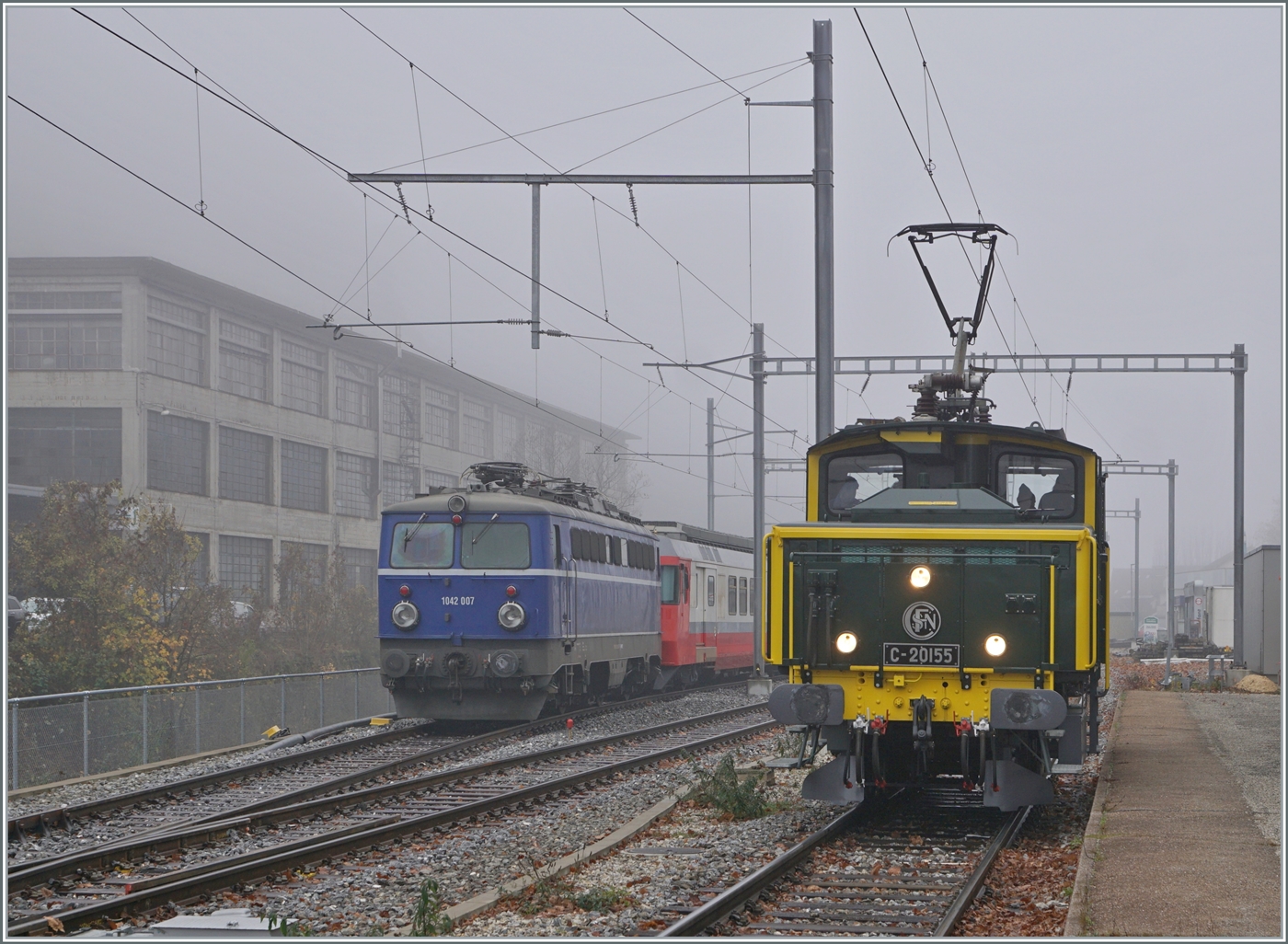 Wenn eine ex SNCF Lok eine ex ÖBB Lok trifft, ist dies ein Bild wert, selbst bei diesem Nebelwetter. Die SNCF C 20155 UIC N° 97 85 1 932-0 (ex SBB Ee 3/3 II 16515, ex SNCF C 20155) führt im Rahmen der offen Tür in Balsthal Führerstandsfahrten Balsthal - Klus - Balsthal aus und erreicht den Bahnhof Klus, während die ex ÖBB 1042 007 (heutige UIC Nummer 91 85 1042 007-1) hier abgestellt ist.

8. November 2025