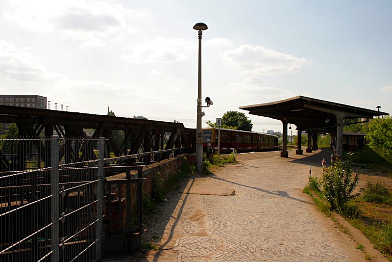 In Schleichfahrt f�hrt auf dem alten Bahnsteig 3 ein Zug auf die rostige Br�cke (Baustelle Berlin Ostkreuz, 10.05.2009).
