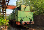 Etwas für Fotos ungünstig stehend, die Verschub-Dampflokomotive Emil Mayrisch 5, eine Krupp Bergbau, am 05 Juni 2011 im LWL-Industriemuseum Henrichshütte in Hattingen (bis 2007 WIM - Westfälisches Industriemuseum).

Die Krupp Typ Bergbau wurde 1953 Lokomotiv- und Waggonbaufabrik Krupp (LOWA) der Friedrich Krupp AG in Essen unter der Fabriknummer 3077 gebaut und als Lok IX an die Gewerkschaft Auguste-Victoria in Marl-Sinsen. Bis zu seiner Schließung 2015 war das Bergwerk das drittletzte aktive Steinkohlebergwerk Deutschlands sowie das zweitletzte im Ruhrgebiet.

1968 ging die Lok aber an die Grube Anna in Alsdorf des EBV - Eschweiler Bergwerks-Verein AG und wurde 1983 als ANNA Nr. 7 geführt, von 1983 bis zur Ausmusterung 1992 wurde die Lok  Emil Mayrisch 5  geführt. Im Jahr 1993 ging sie an das Bergbaumuseum Wurmrevier e. V. in Alsdorf und ging aber ende der 1990er an das damalige als geführt WIM - Westfälisches Industriemuseum, Standort Henrichshütte in Hattingen. 

Beschreibung des Typs  Bergbau  der Lokomotivfabrik Krupp (Essen):
Die normalspurige, vierachsige Tenderlokomotive war Teil des Nachkriegs-Typenprogramm Lokomotivfabrik in Essen und wurde sowohl in einer Naßdampf- als auch in einer Heißdampfversion geliefert. Zwischen 1948 und 1962 entstanden 30 Lokomotiven dieses Typs in der Lokomotivfabrik Krupp AG. Die  Bergbau  war nicht nur die leistungsstärkste, sondern mit Abstand mit 80 t die schwerste Maschine unter den Nachkriegsbauarten. 

Entstehungsgeschichte:
Während des Zweiten Weltkrieges erhielt Krupp den Auftrag zur Entwicklung einer schweren Dh2t-Lokomotivbauart für die Reichswerke Hermann Göring in Salzgitter, nach 1945 ging diese endgültig in der Salzgitter AG auf, die sich bis Ende der 1980er Jahre im Besitz der Bundesrepublik Deutschland befand. Nach Abschluss der Konstruktionsarbeiten wurde der Bau der 13 bestellten Maschinen kriegsbedingt zur Firma Werkspoor in Utrecht verlagert. Die Niederlande war ja von den deutschen Truppen besetzten worden. Bis zum Kriegsende konnte allerdings keine Lok fertig gestellt werden. Die angearbeiteten Baugruppen wurden kurz vor dem Abzug der Besatzungstruppen noch nach Essen überführt, wo sie nach Komplettierung und Endmontage ab 1948 zur ersten Serie der Bergbau wurden. 

Bauart:
Die Krupp Bergbau war für den schweren Übergabe- und Verschubdienst von Industrie- und Werksbahnen konzipiert. Entsprechend diesem Einsatzzweck war sie besonders robust und kräftig ausgeführt. Dank ihres vergleichsweise hohen Kesseldrucks, der großen Zylinder und des günstigen Übersetzungsverhältnisses war die mit vollen Vorräten 80 t schwere und rund 1.000 PSi starke Lok nicht nur die leistungsfähigste Type des Krupp-Industrielokprogramms, sondern die schwerste und stärkste vierachsige deutsche Tenderlok überhaupt. Im unteren Geschwindigkeitsbereich übertraf ihre Zugkraft sogar die der sechsachsigen Schlepptenderlok der Baureihe 50. Die zulässige Höchstgeschwindigkeit betrug 50 km/h. Zwecks Erzielung günstiger Kurvenlaufeigenschaften lagen nur der erste und dritte Radsatz fest im Rahmen, der zweite und vierte Radsatz waren jeweils um 15 mm seitenverschiebbar.

Die Type wurden in mehreren Baulosen gefertigt, die sich teilweise äußerlich unterscheiden lassen; die ersten beiden Serien besaßen viereckige Führerhausstirnfenster nach Art der Kriegslokomotiven, kantige Führerhausdächer und zwei sichtbare Kesselaufbauten (Dampfdom mit zwei Sandkästen unter gemeinsamer Verkleidung, separater Speisedom); später gebaute Loks hatten ovale Stirnfenster, abgerundete Führerhausdächer sowie eine durchgehende Verkleidung von Speisedom, Dampfdom und nur noch einem Sandkasten. Da sich der Wasservorrat von zunächst 8 m³ bei den auf der Hafenbahn der HOAG (Walsum – Oberhausen) eingesetzten Loks als etwas knapp erwiesen hatte, wurde ein Teil der später gebauten Maschinen mit vergrößerten hinteren Vorratsbehältern ausgerüstet. Der hintere Überhang wuchs dadurch um 150 mm, der Wasservorrat nahm auf 10 m³ zu. Einige Maschinen wurden ab Werk mit einem Mischvorwärmer ausgerüstet.

TECHNISCHE DATEN:
Gebaute Anzahl: 30
Baujahre: 1948 bis 1962
Bauart: D n2t oder D h2t
Spurweite: 1.435 mm (Normalspur)
Länge über Puffer: 11.100–11.250 mm (je nach Bauserie)
Höhe: 4.150 mm
Breite: 3.130 mm
Gesamtachsstand: 4.500 mm (3 x 1.500 mm)
Treibraddurchmesser: 1.200 mm (neu)
Dienstgewicht: 80 t
Höchstgeschwindigkeit: 50 km/h (vorwärts / rückwärts), diese zuletzt 25 km/h
Indizierte Leistung: 735 kW / 1.000 PS
Anfahrzugkraft: 223 kN
Kesselüberdruck: 15 bar
Zylinder: 2 (Ø 630 mm x 600 mm Hub)
Steuerungsart: Heusinger auβen
Rostfläche: 2,46 m² 
Überhitzerfläche: 42 m² 
Verdampfungsheizfläche: 118 m²
Wasservorrat: 10,0 m³
Kohlevorrat: 3 t
Kleinster bef. Halbmesser: 100 m
Bremse: Knorr 
