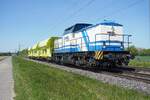 NeoLox 203 221 zieht drie GATX Selbstentladewagen am 24 April 2026 durch Kaarst-Broicherseite und wird vom offenbarer Stelle fotografiert.