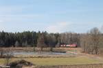 233 698 zieht den EZ 51716 Nrnberg - Senftenberg samt E-Lok kurz vor Wiesau/Oberpfalz und hat den Wald passiert.