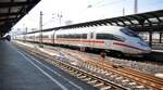 ICE 3 auf dem Weg nach München, hält in Ulm und überholt dabei den auf Gleis 1 stehenden Kalkzug mit 185 001-5 am 09.02.2023.