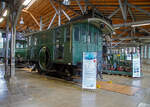 Die Drehstrom- Elektrolokomotive ex BTB De 2/2 Nr.1, ex BTB F 2/2 Nr. 1 (1902 – 1922), ex BTB E2E Nr. 1 (bis 1902), am 11.09.2022 in der Lokwelt Freilassing. Die Lok ist Eigentum des Deutschen Museums - Verkehrszentrum in München und eine Leihgabe die Lokwelt Freilassing

Dem Güterverkehr der Burgdorf-Thun-Bahn (BTB) dienten zwei Lokomotiven vom Typ F 2/2. Bis 1902 wurden sie als E2E bezeichnet, ab 1922 als De 2/2. Diese beiden ersten in der Schweiz, im Jahr 1899, gebauten elektrischen Lokomotiven (De 2/2 Nr.1 und  2) waren eine gemeinsame Konstruktion der Schweizerischen Lokomotiv- und Maschinenfabrik (SLM) in Winterthur für den mechanischen Teil und der Brown, Boveri & Cie. (BBC) für die elektrische Ausrüstung. 

Der noch nicht ausgereifte Einphasen-Wechselstrom-Betrieb konnte zur damaligen Zeit noch nicht eingesetzt werden. Deshalb beschaffte die Schweizer Burgdorf-Thun-Bahn (BTB) zunächst für den reinen Güterzugbetrieb zwei dieser mit Drehstrom (Dreiphasenwechselstrom) angetriebenen Lokomotiven. Das Drehstrom-System konnte nur in einem bestimmten Geschwindigkeitsbereich effektiv arbeiten, so dass ein mechanisches Schaltgetriebe für zwei maximale Geschwindigkeiten notwendig war, nämlich für 18 und 36 km/h.

Ab 1933 wurde der Drehstrombetrieb auf dieser Strecke eingestellt und die beiden Lokomotiven ausgemustert. Die beiden Lokomotiven sind als weltweit erste Drehstromlokomotiven für den Vollbahnbetrieb erhalten geblieben. Die Nr. 1 befindet in der Lokwelt Freilassing, die Nr. 2 befindet sich im Verkehrshaus der Schweiz in Luzern.

Die beiden Motoren wiesen eine Leistung von je 150 PS (110 kW) auf. Das nur im Stillstand umschaltbare Getriebe ermöglichte zwei Geschwindigkeiten, Die eine bis 18 km/h ließ auf der größten Steigung von 25 ‰ eine Anhängelast von 100 Tonnen zu, die andere bis 36 km/h noch die Hälfte. Wobei die zulässige Höchstgeschwindigkeit betrug 50 km/h, so wurde in den späteren Betriebsjahren in Gefällen stromlos gefahren, um diese zu erreichen. Dank der höheren Geschwindigkeit hätten die Lokomotiven nötigenfalls auch im Personenverkehr Verwendung finden können.

Die beiden 19-poligen Triebmotoren sind beidseits auf einer auf einem Hilfsgestell gelagerten gemeinsamen Welle montiert. Über ein Vorgelege wurde das Drehmoment mittels Kuppelstangen auf die beiden Achsen übertragen. Zum Anfahren war ein für beide Motoren gemeinsamer Widerstand vorhanden, der mit dem in jedem Führerstand vorhandenen Kontroller allmählich ausgeschaltet wurde. Beleuchtung, Heizung und Hilfsbetriebe wurden mit einer Spannung von 100 Volt betrieben. Die Lokomotiven weisen an beiden Enden offene Plattformen auf. Die vier Schleifbügel auf dem Dach legten sich selbsttätig beim Wechsel der Fahrtrichtung nach hinten um. Zum Abbügeln mussten die an den Bügeln angebrachten kurzen Zugseile vom Boden aus mit hölzernen Stangen heruntergezogen und in Arretierhaken eingehängt werden.

TECHNISCHE DATEN:
Baujahr: 1899, Ausmusterung1930
Spurweite: 1.435 mm (Normalspur)
Achsfolge: B
Länge über Puffer: 7.800  mm
Achsabstand: 3.140 mm
Treibraddurchmesser:  1.230 mm
Dienstgewicht: 29.600 kg
Höchstgeschwindigkeit: 18 km/h / 36 km/h (stromlos bergab 50 km/h)
Stundenleistung: 300 PS (220 kW)
Stundenzugkraft: 4.400 daN
Stromsystem: 750 V, 40 Hz ∆
Anzahl der Fahrmotoren: 2
Übersetzungsstufen: 2 (für 18 / 36 km/h)

Die Burgdorf-Thun-Bahn (BTB) war eine Eisenbahngesellschaft in der Schweiz. Ihre Strecke von Burgdorf über Konolfingen nach Thun wurde als erste elektrische Vollbahn der Schweiz im Jahr 1899 dem Betrieb übergeben. Heute ist sie Bestandteil der BLS AG