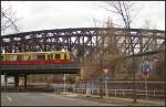 Blick auf die Liesenstra�enbr�cke mit vorbeifahrender S-Bahn und einem Mauerst�ck in Berlin Humboldthain
