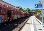 Offener Sch�ttgutwagen mit schlagartiger Schwerkraftentladung, hydraulischem Klappenverschlusssystem und 4 Rads�tzen, der Gattung Falns 121, der DB Cargo AG, eingestellt als 81 80 6645 164-7 D-DB, am 28 Juli 2026 im Zugverband (Zugschluss) bei einer Zugdurchfahrt in Kirchen (Sieg).

Gut abgestimmt: Die gleichzeitige �ffnung bzw. Schlie�ung aller vier Klappen wird durch Bet�tigen eines Steuerventils entweder von der Wagenb�hne oder vom Bunkersteg aus mit einem speziellen langstieligen Vierkantschl�ssel m�glich.

Der Wagenkasten besteht aus einem sattelf�rmigen Boden, den fest mit den Untergestell-Fachwerktr�gern verbundenen Stirnw�nden, den Seitenw�nden, den vier an den Seitenw�nden aufgeh�ngten Entladeklappen (Seitenklappen) und dem Quersattel, der den Wagenkasten in zwei gleichgro�e Kammern unterteilt.

Der sattelf�rmige Boden ist eine Fachwerktr�ger-Konstruktion in Segmentbauweise, deren Untergurte die Langtr�ger und deren Obergurte den First unter dem Firstwinkel bilden. Die Sattelneigung betr�gt 49� zur Waagerechten. Zwischen den Langtr�gern befinden sich die Hauptquertr�ger, Quertr�ger sowie die Tr�ger f�r die Druckluftbremseinrichtung und den Antrieb des Klappenverschlusses. Die Kopfst�cke des Untergestells sind mit festen Druckanschl�gen f�r die Aufnahme der Zugeinrichtung ausgef�hrt. Der vollst�ndig geschwei�te Wagenkasten wird durch Quersattel und mittlere Trennwand in zwei gleich gro�e Kammern unterteilt.

Im unteren Bereich sind je Seite zwei gro�e Auslauf�ffnungen vorgesehen, die durch stabile Seitenklappen geschlossen werden. Der Wagenkasten ist �berwiegend durch Hohlprofile ausgesteift. Die Ecken sind durch gro�e Eckf�llbleche ausgerundet. F�r s�mtliche Bleche wurde Werkstoff der Qualit�t S355J2G3 verwendet mit Ausnahme des oberen Saumeisens (QStE 500 N) sowie der Langtr�ger der Sattelblechverst�rkung (QStE 380). Das �ffnen und Schlie�en der Klappen erfolgt �ber einen hydraulisch angetriebenen Daumenwellenverschluss, der gegen�ber den Vorg�ngerbauarten (z.B. Falns 183) sowohl im hydraulischen als auch im mechanischen Teil komplett �berarbeitet und optimiert wurde.

Die vier Seitenklappen werden gleichzeitig ge�ffnet oder geschlossen. Das f�r die hydraulischen Einrichtungen ben�tigte Druck�l wird von einer Radsatzpumpe w�hrend der Fahrt (nach ca. 4 km Fahrweg mit mind. 10 km/h ist der Speicher aufgeladen) in einen Gasdruckspeicher gef�rdert. Zur Pr�fung, ob die Klappen ordnungsgem�� verschlossen sind, dient eine in Wagenmitte auf beiden Seiten angebrachte Anzeigeeinrichtung (gelbe Signalscheiben). Diese Signalscheiben ragen �ber die Wagenseitenwand hinaus, wenn die Klappen nicht einwandfrei verschlossen und verriegelt sind.

TECHNISCHE DATEN:
Spurweite: 1.435 mm (Normalspur)
Anzahl der Achsen: 4
L�nge �ber Puffer: 13.040 mm
Drehzapfenabstand: 7.700 mm
Achsabstand im Drehgestell: 1.800 mm
L�nge der Belade�ffnung: 12.120 mm
Breite der Belade�ffnung: 1.812 mm
Laderaum: 90,0 m�
L�nge einer Seitenklappe: 5.325 mm
Gr��ter Seitenklappenausschlag: 4.000 mm
Klappenverschlusssystem: hydraulisch
Wagenh�he: 4.307 mm
H�chstgeschwindigkeit: 120 km/h (leer) / 100 km/h (beladen)
Max. Ladegewichte: 58 t ab Streckenklasse C / 66,0 t ab D 3 
Max. Ladegewichte auf DB Netz: 59,0 t ab CM2 / 60,0 t ab CM3 (max.100 km/h)
Eigengewicht: 23.700 kg
Drehgestell-Bauart: 655/656
Kleinster bef. Gleisbogenradius: 75 m
Bremse: KE- GP (K)
Bremssohle: K-Sohle, Jurid 816 M
Intern. Verwendungsf�higkeit: Durch Sondervereinbarungen / G 2 / F�r den Einsatz in Deutschland, Polen, �sterreich und den Niederlanden zugelassen.
