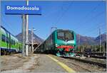 Die Trenord E 464 122 wartet mit einem Regionalzug in Domodossola auf die Abfahrt in Richtung Milano.

28. Okt. 2021