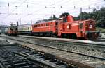 �BB 2067.60 schleppt 1110.06 mit Zug aus stromlosen Bereich; im Hintergrund befindet sich ein Turmtriebwagen X 534 im Arbeiteinsatz in Bregenz am 12.06.1983.
