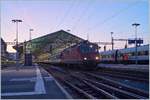 Ein leichtes Morgenrot breitet sich über dem noch im Schatten liegenden Bahnhof von Lauanne aus, im Vordergrund ist eine SBB Re 4/4 II mit ihrem RE aus St-Maurice eingetroffen.