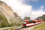 Der Bergsturz von Randa: Aufstieg im Abstieg. Talabwärts fahrende Züge müssen nach der Station Randa den steilen Aufstieg zum Scheitelpunkt der Umfahrungsstrecke bewältigen. Im Hintergrund der Bergsturz. Im Bild ein  Komet -Zug, dessen hinterster Wagen der Doppelsteuerwagen ABt 2131 ist. Durch die Einheitlichkeit des Designs der Komet-Züge sieht man kaum, dass es sich um einen separaten Doppelwagen handelt. 30.August 2025 